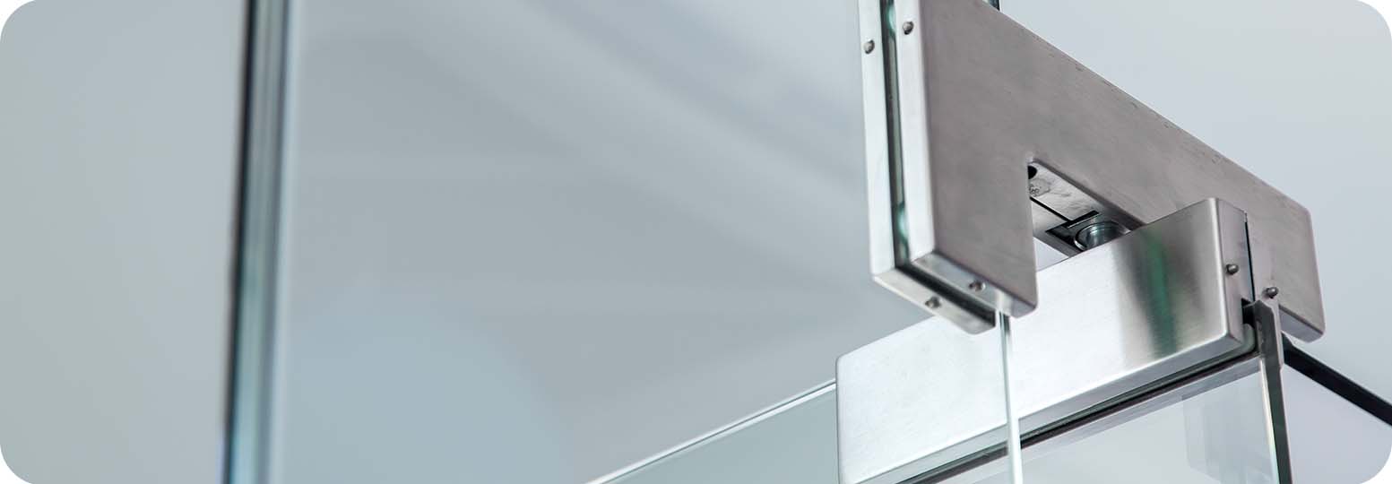 a close up of a glass pivot door and its hinges